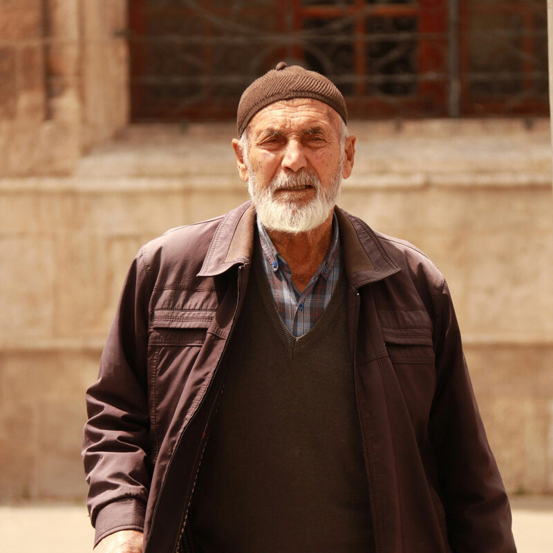 Turkish man standing in front of a building