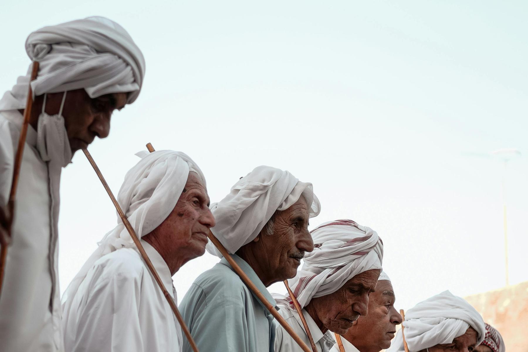 Older men in white galabiyas and turbans